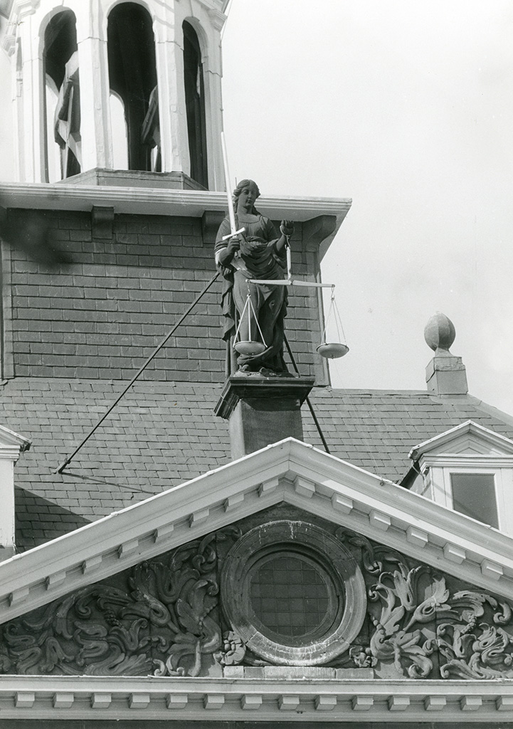 Vrouwe Justitia op het Vlaardingse stadhuis, met weegschaal en zwaard, zonder blinddoek. Foto Collectie Stadsarchief Vlaardingen, T363B-274.