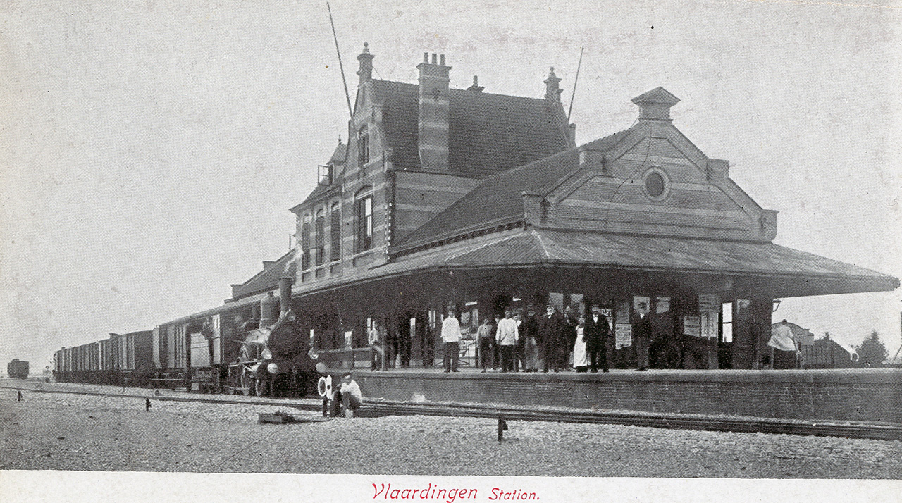 Een ansichtkaart van het fraaie stationsgebouw. Voor het gebouw staat een locomotief met goederenwagons. Collectie Stadsarchief Vlaardingen, T525-007-1.