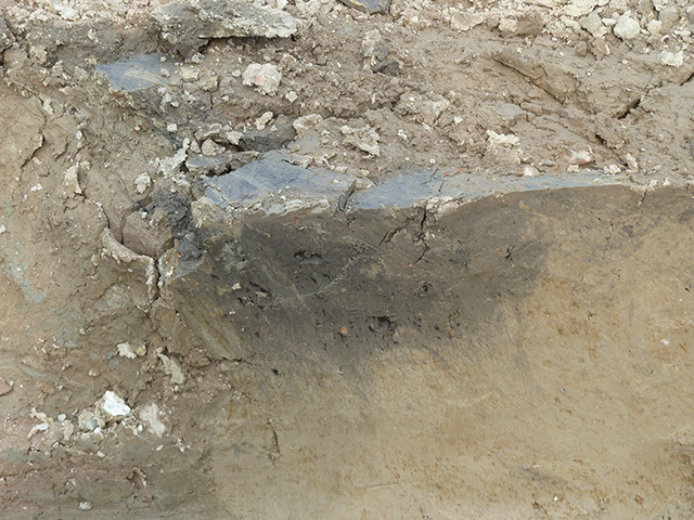 Een kuil uit de Romeinse tijd met houtskoolspikkels. Fotograaf: T. de Ridder, Collectie Archeologie Vlaardingen.