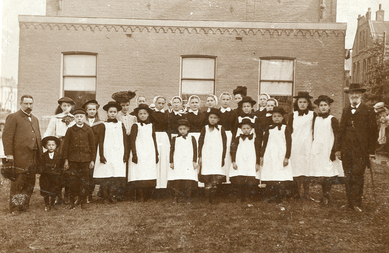 Vlaardingse weeskinderen met weesvader en -moeder H. Faassen en M. Faasen-van Diemen rond 1898. Fotograaf: J.F.L. Ball, Collectie Stadsarchief Vlaardingen, P0374-2.